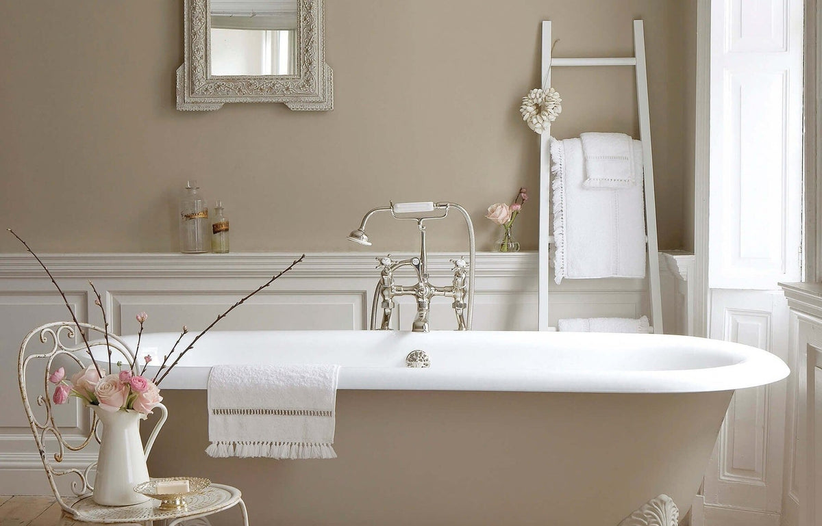 Greige badkamer met Little Greene Rolling Fog (158) op de wand, met vrijstaand bad, spiegel en handdoekladder