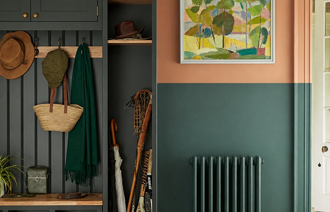 Halletje met een half geverfde muur: diepgroen op de onderste band en terracotta erboven.
