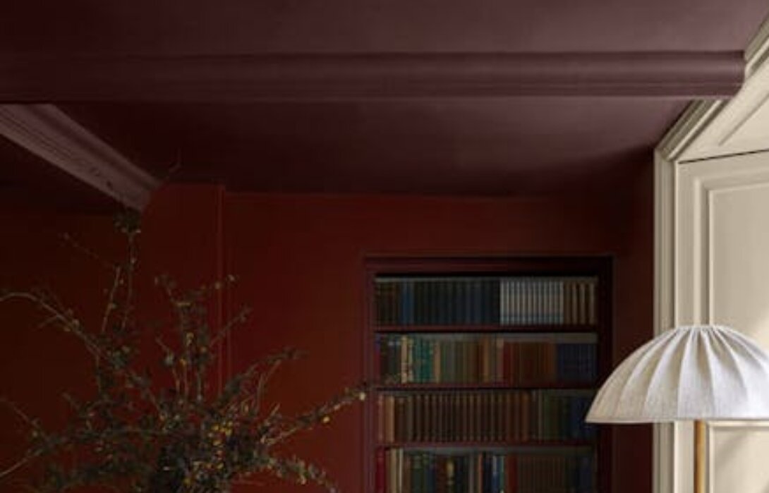 Hoek met muren in Little Greene Bronze Red en een diep aubergine plafond en kroonlijst in Little Greene Arras.