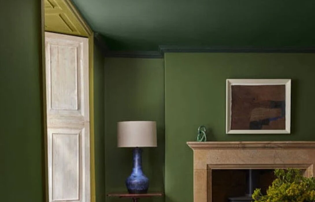 Woonkamer in double drenching: muren in Little Greene Hopper, plafond in Dark Brunswick Green, raamlijst in Citrine