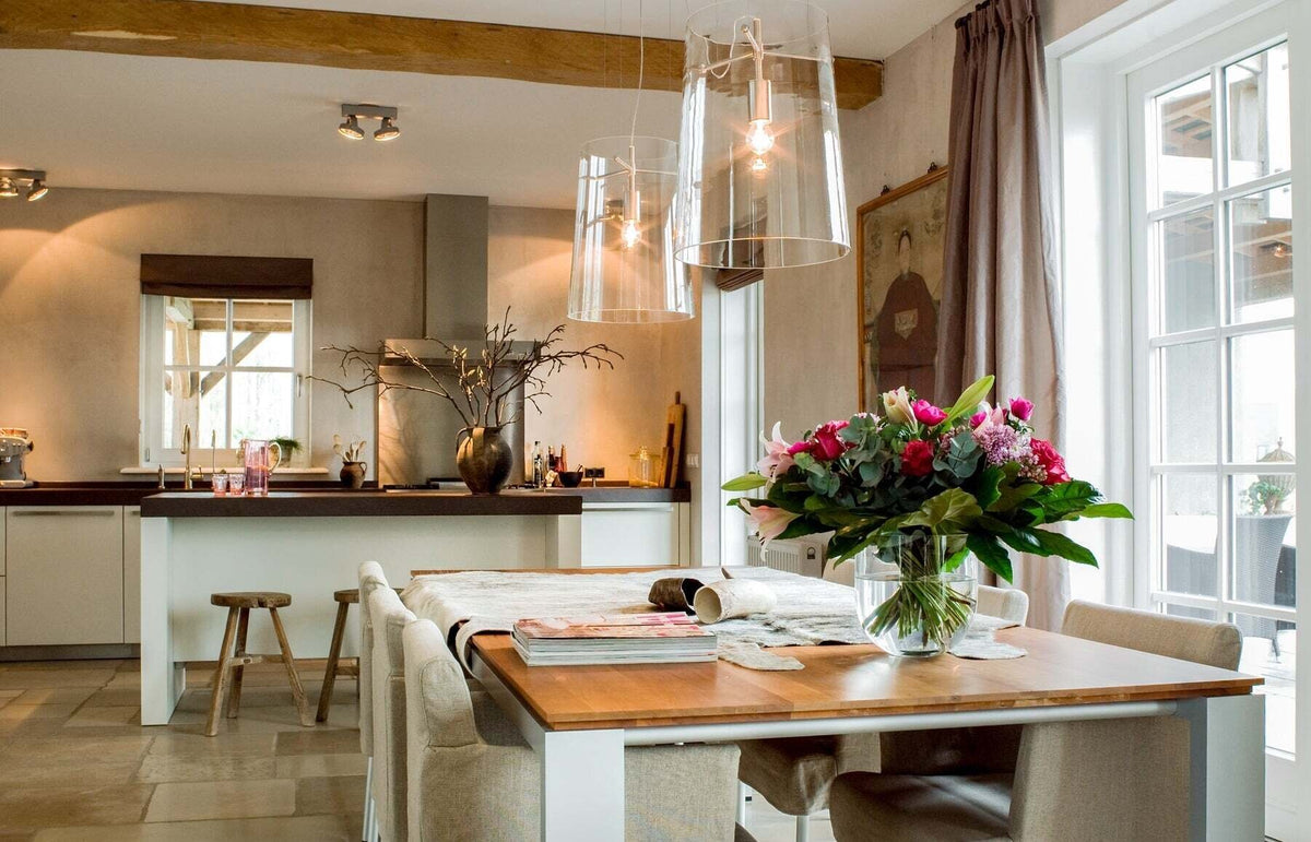 Landelijke keuken met warme beige gepleisterde wanden in Pure & Original Canvas, met eettafel, bloemen en natuurstenen vloer.