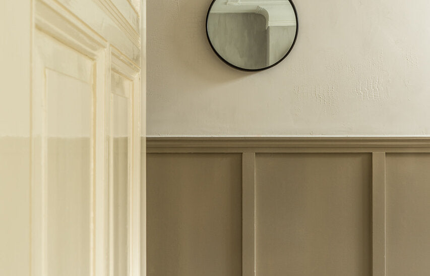 Crème houtwerk naast een witte wand in Pure & Original Natural Rice (Marrakech Walls) met taupe lambrisering in Pebble Stone (Traditional Paint), met ronde spiegel en glazen hanglamp