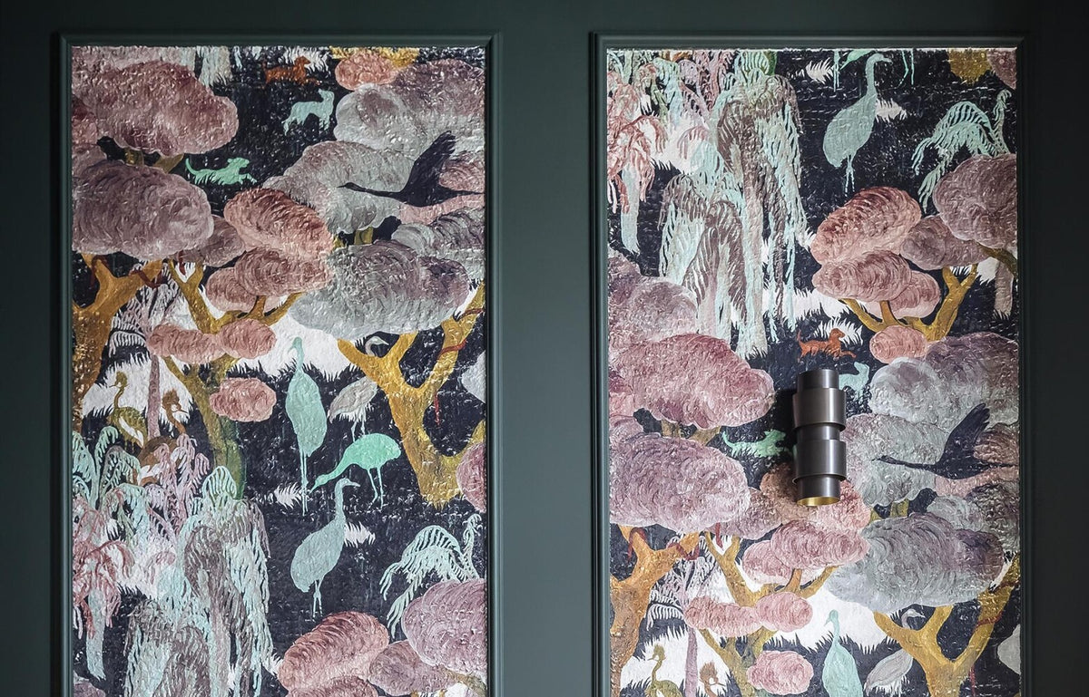 Arte-behang met kraanvogels in twee sierlijst-kaders op een donkergroene woonkamerwand
