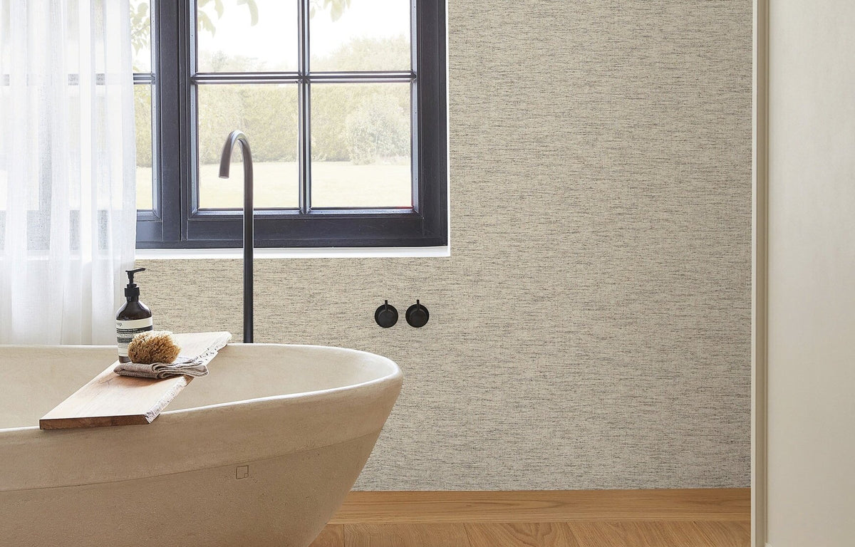 Waterbestendig grasscloth-behang van Arte in een badkamer met bad en raam
