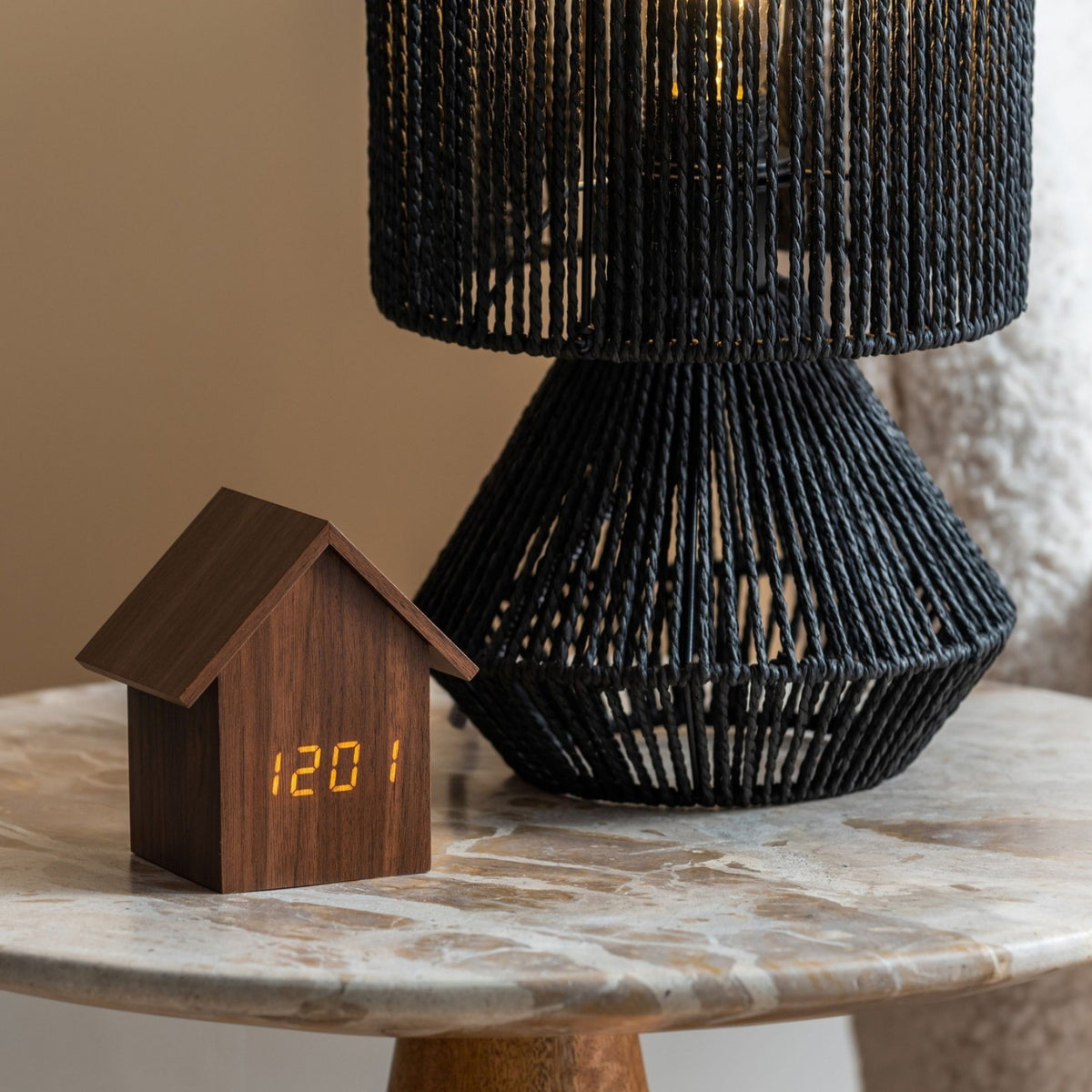 Karlsson wekker House Led, donker hout fineer, sfeerfoto: op marmeren bijzettafel naast zwarte rotan lamp