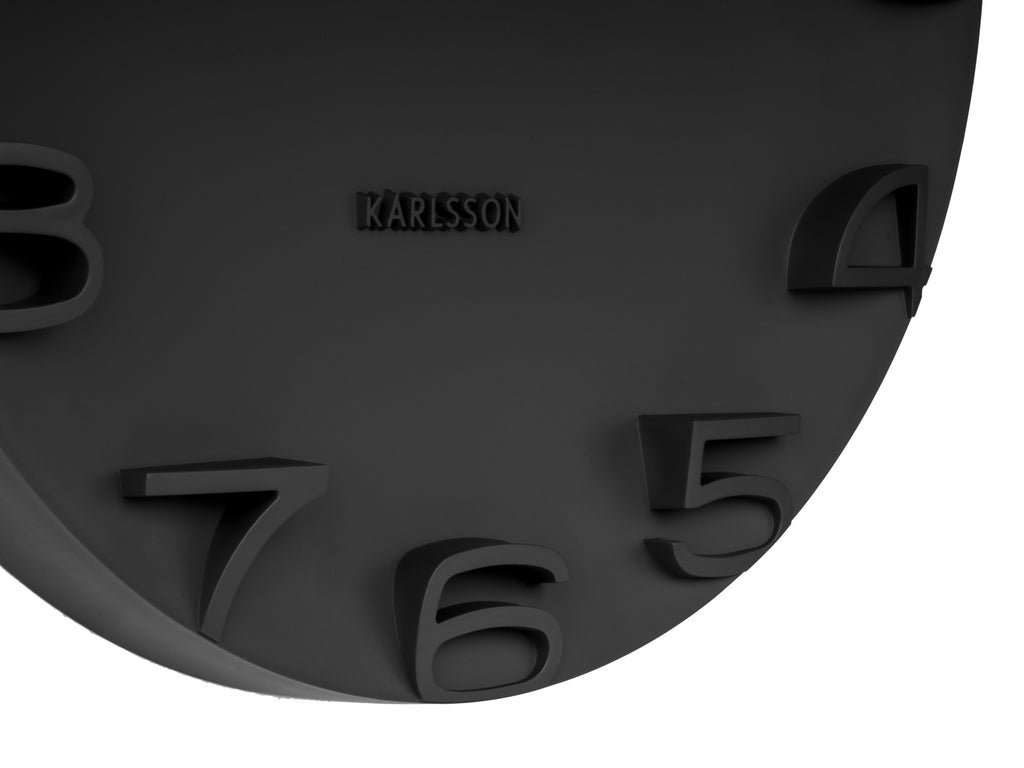 Karlsson wandklok On The Edge, zwart met chromen wijzers, detail: reliefcijfers 4 tot 8 en Karlsson-logo