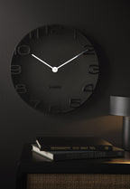 Karlsson wandklok On The Edge, zwart met chromen wijzers, sfeerfoto in interieur