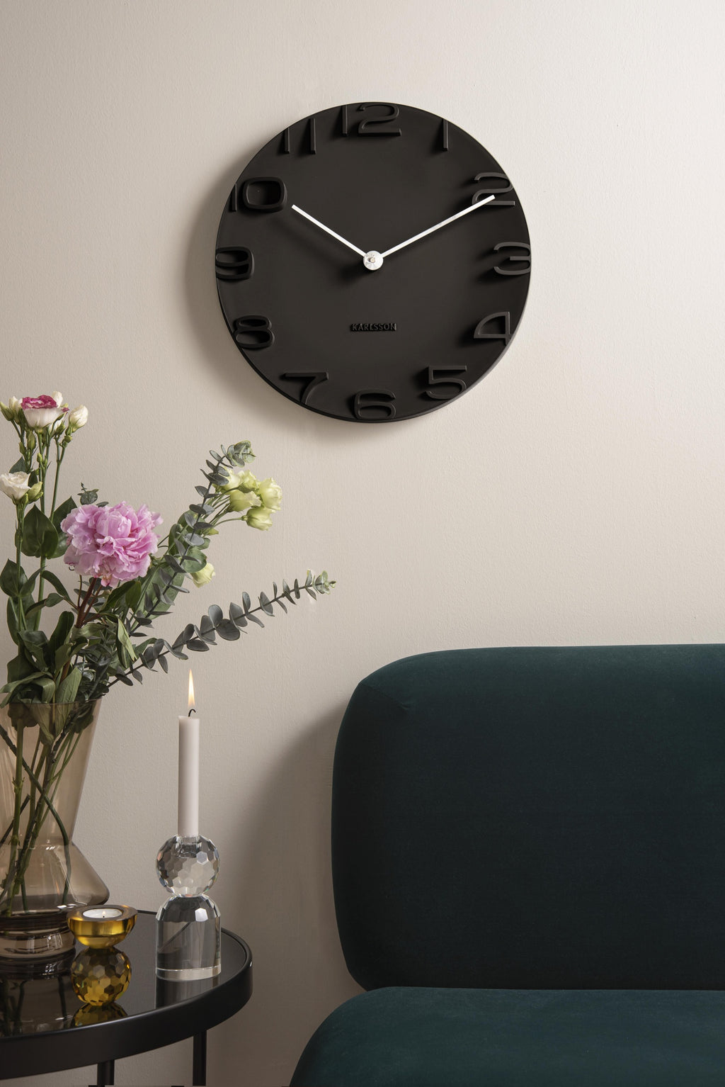 Karlsson wandklok On The Edge, zwart met chromen wijzers, sfeerfoto in interieur