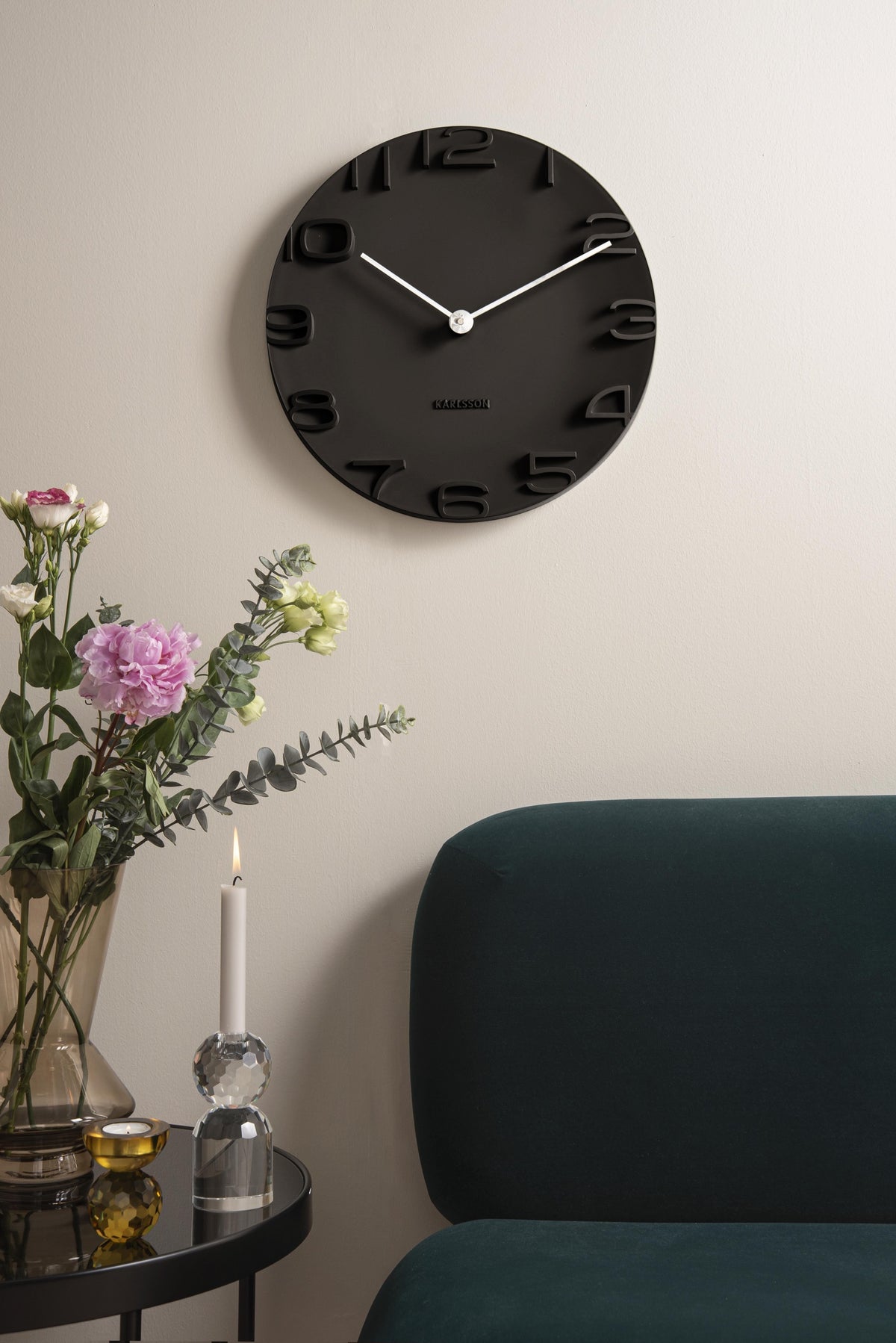 Karlsson wandklok On The Edge, zwart met chromen wijzers, sfeerfoto in interieur