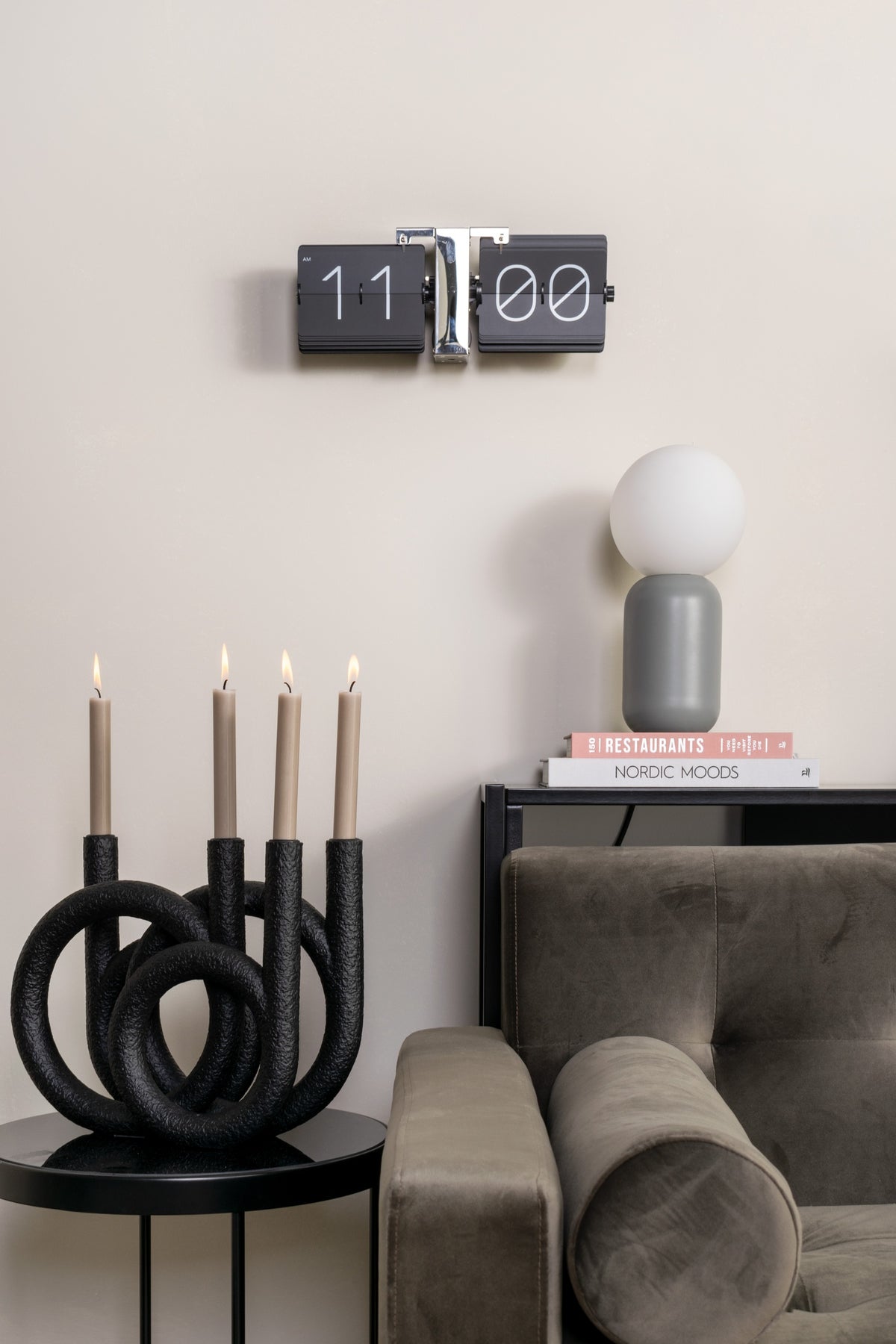 Karlsson flipklok Flip Clock No Case, zwart met chromen standaard, sfeerfoto: aan beige muur boven kandelaar en bank