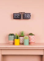 Karlsson flipklok Flip Clock No Case, zwart met chromen standaard, sfeerfoto: aan roze muur boven schouw met cactussen