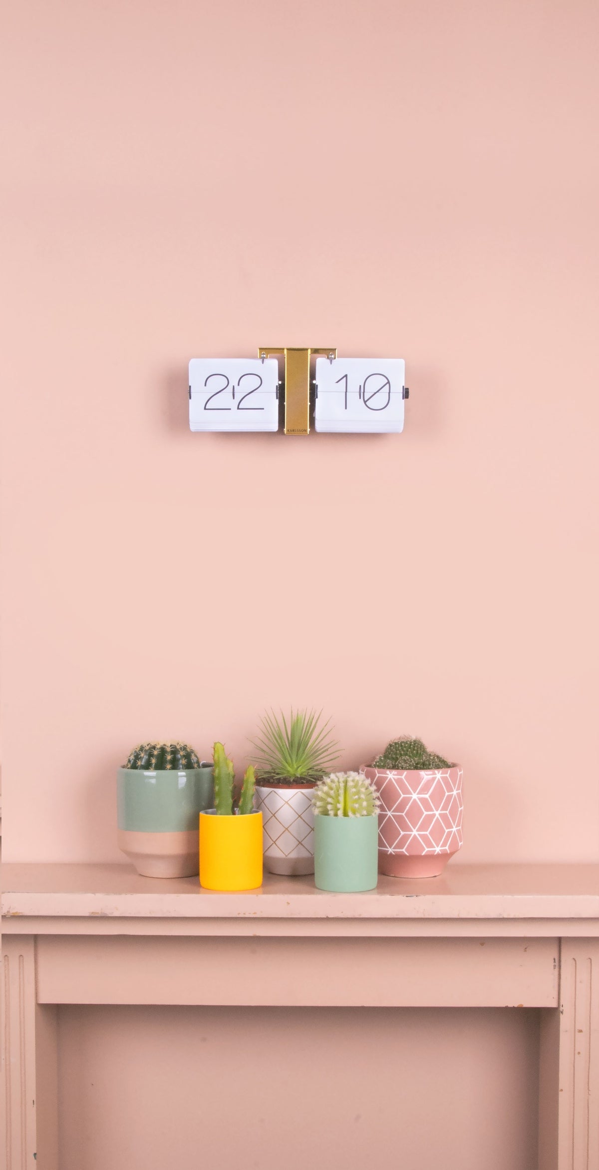 Karlsson flipklok Flip Clock No Case, wit met messing standaard, sfeerfoto: aan roze wand boven schouw met cactussen