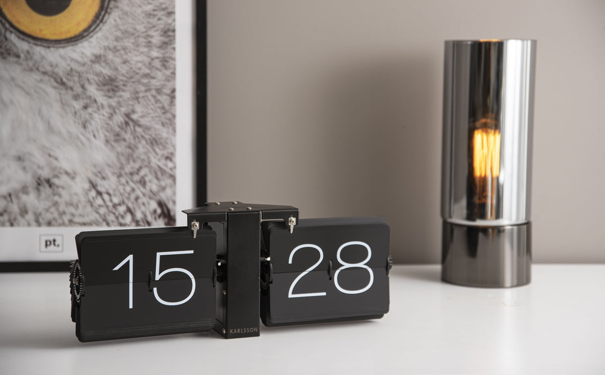 Karlsson flipklok Flip Clock No Case, mat zwart met zwarte standaard, sfeerfoto: op wit bureau naast rookglazen lamp