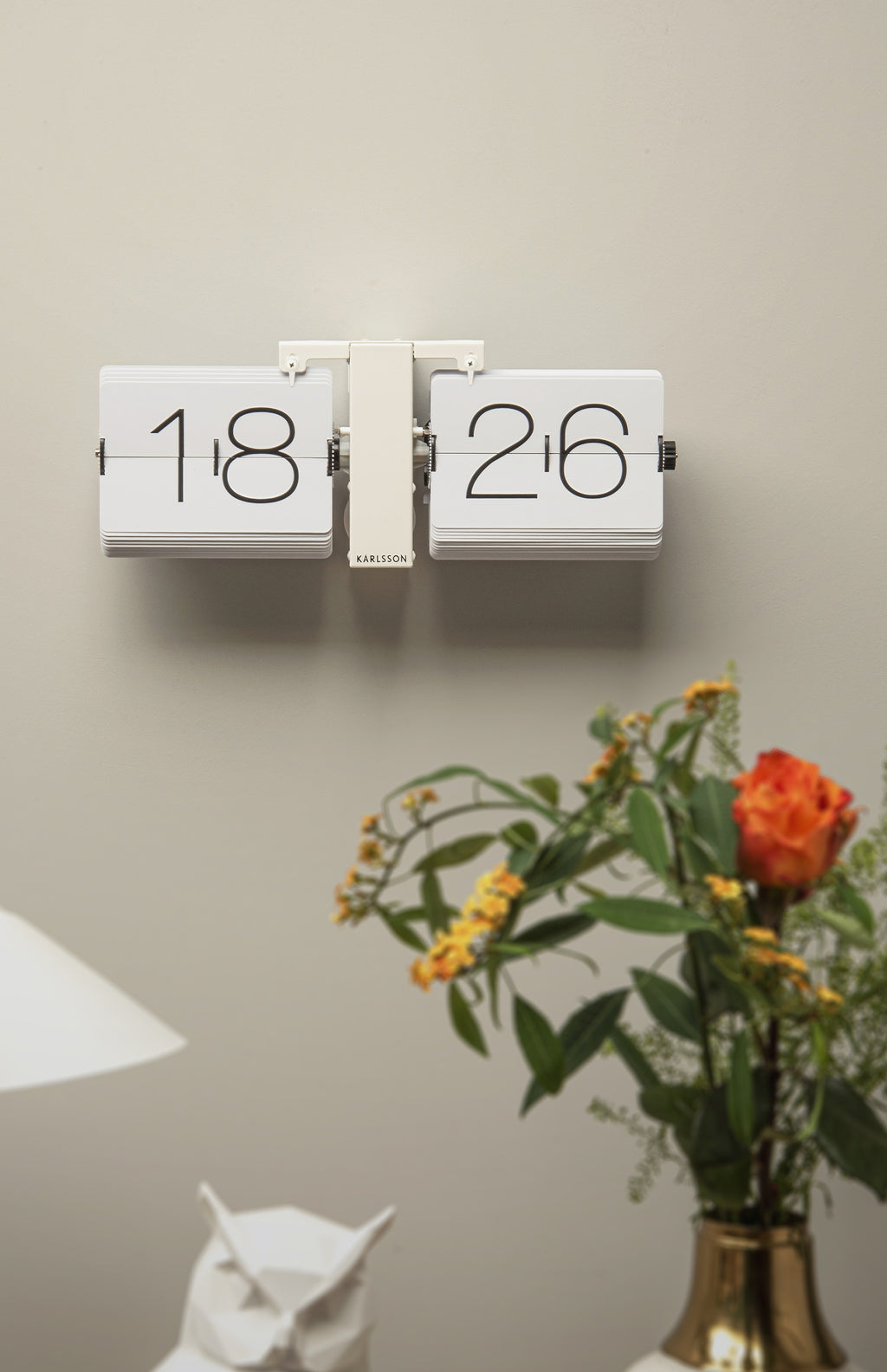 Karlsson flipklok Flip Clock No Case, mat wit met witte standaard, sfeerfoto: aan beige wand boven bloemen