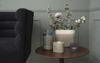 Karlsson wekker Mini Cube, zwart fineer, witte led, sfeerfoto: op ronde bijzettafel naast vazen en bloemen
