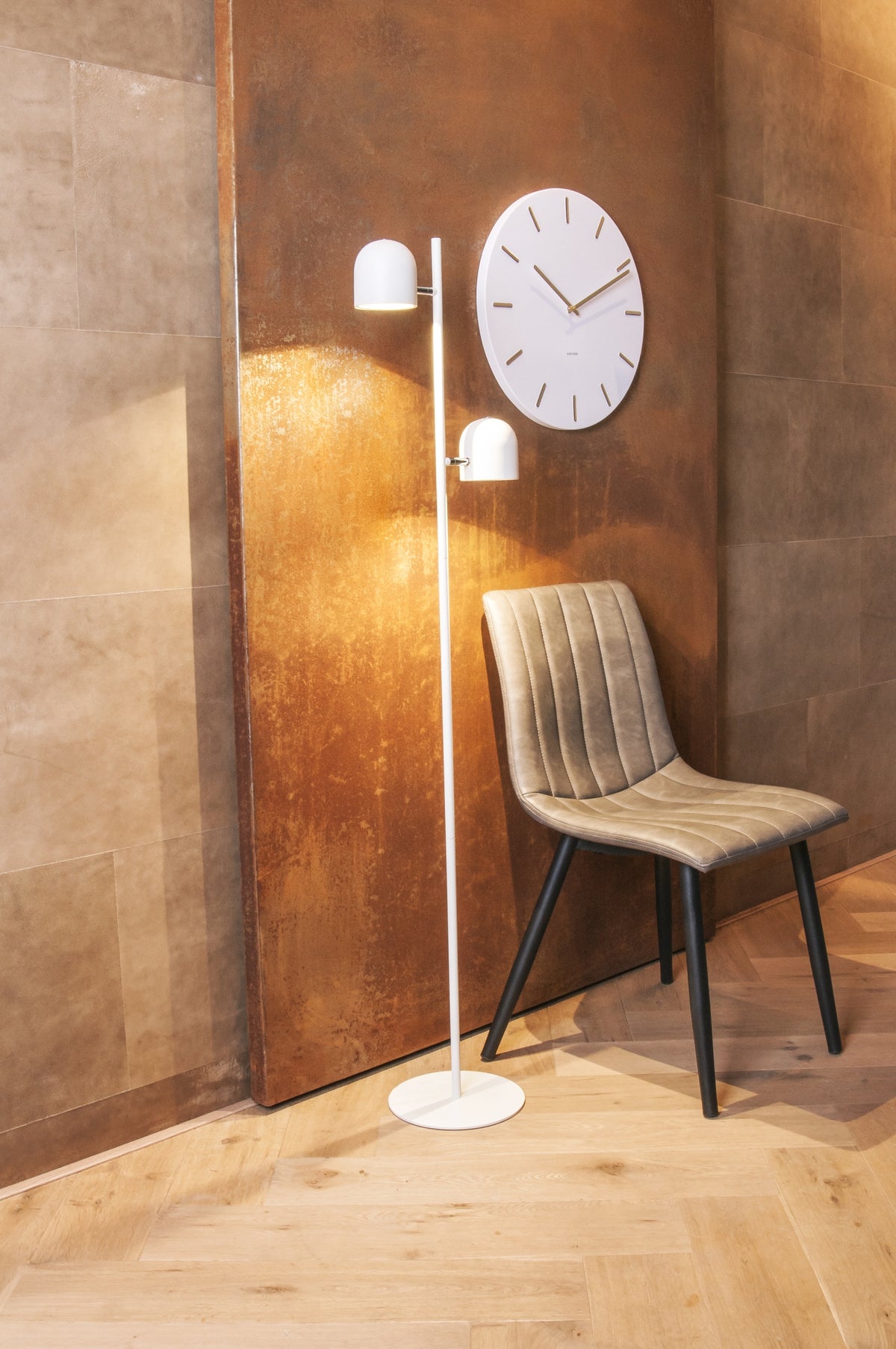 Karlsson wandklok Charm, wit, sfeerfoto: aan roestbruine wand naast witte vloerlamp en beige stoel