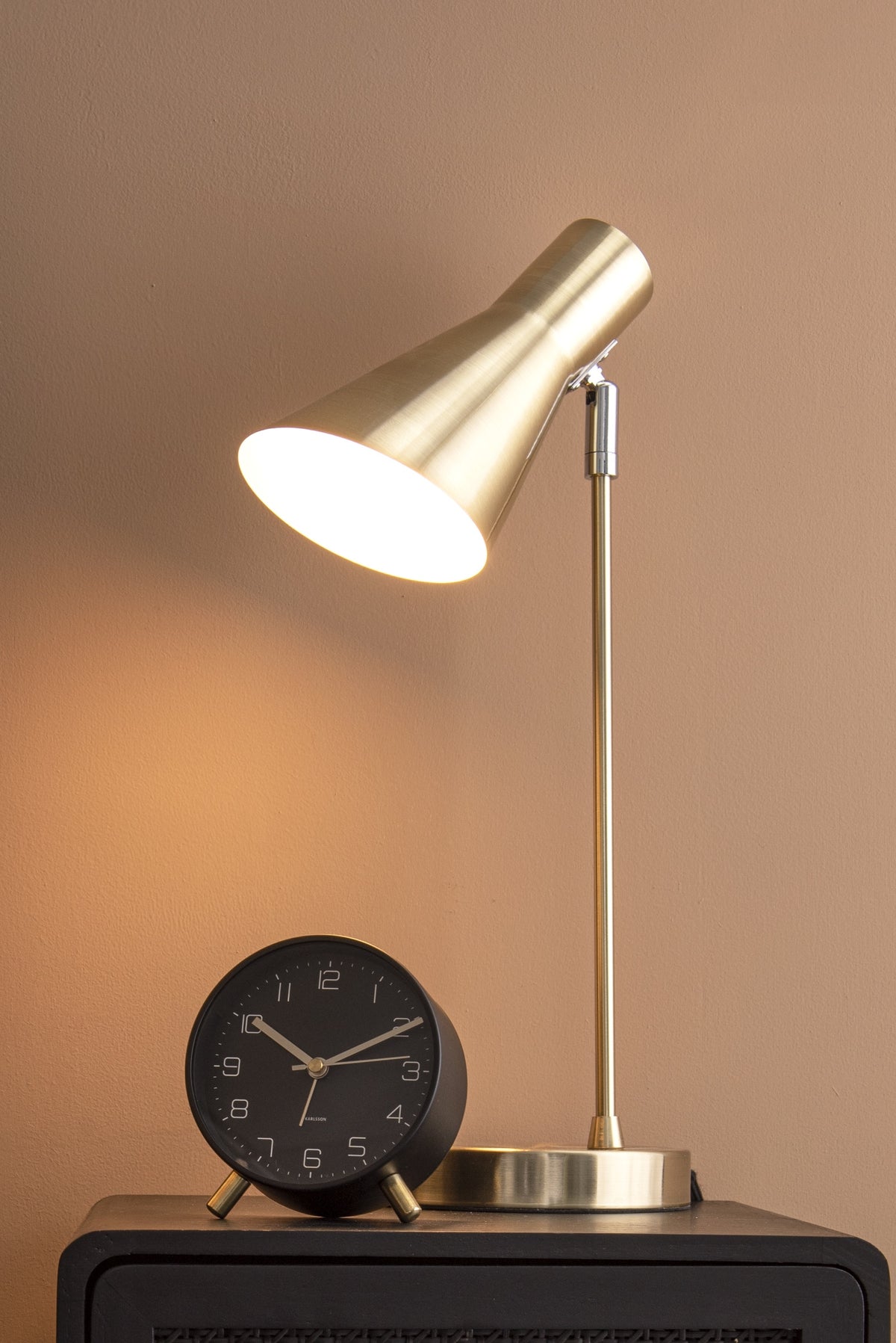 Karlsson wekker Lofty, metaal mat zwart, sfeerfoto: op boeken naast groene glazen lamp en plant