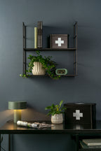 Karlsson wekker Gummy Rubberized, groen, sfeerfoto: op wandrek aan donkerblauwe wand met plant en boeken