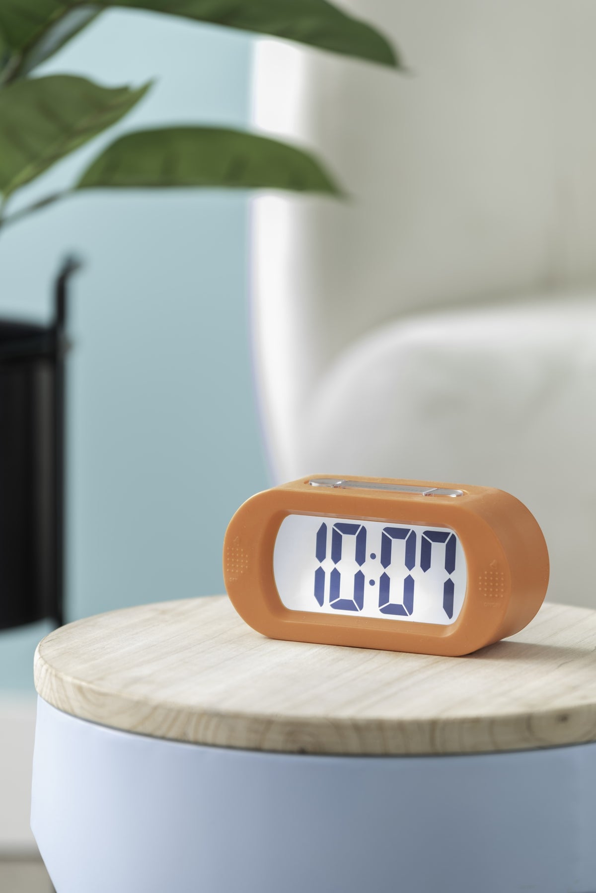 Karlsson wekker Gummy Rubberized, helderoranje, sfeerfoto: op houten bijzettafel, display toont 10:07
