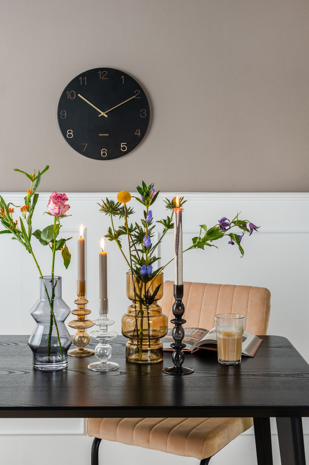 Karlsson wandklok Charm Small, gegraveerde cijfers, zwart, sfeerfoto: aan taupe wand boven eettafel met vazen