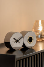 Karlsson koekoeksklok Duo Cuckoo, chrome (verchroomd), sfeerfoto: op donker dressoir bij warme tafellamp
