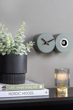 Karlsson koekoeksklok Duo Cuckoo, mat jungle groen, sfeerfoto: aan grijze wand naast plant, boeken en geribbelde lamp