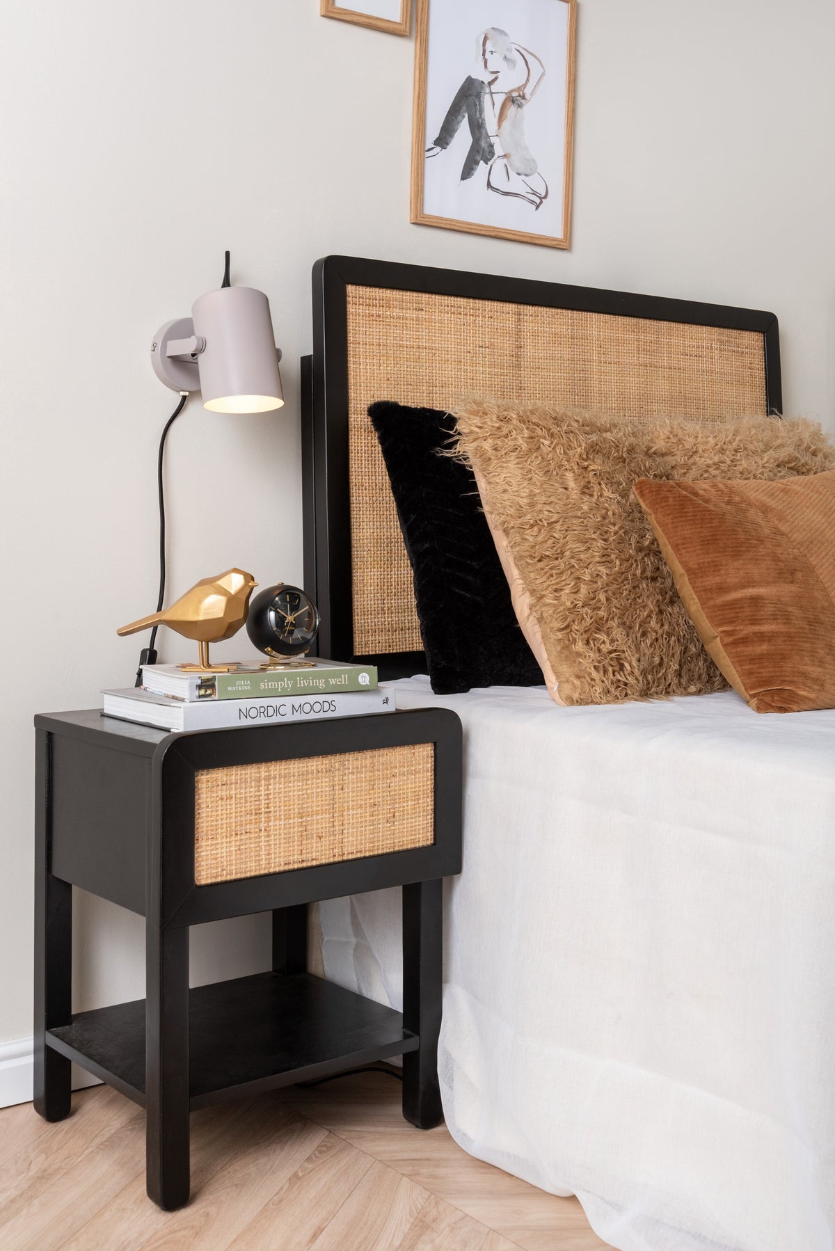 Karlsson wekker Globe Armando Breeveld, zwart, sfeerfoto: klein op nachtkastje naast bed met rotan hoofdbord en gouden vogel