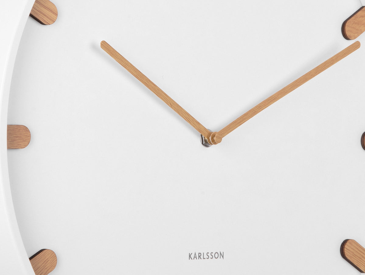 Karlsson wandklok Grace, wit, detail: houten wijzers en houten streepjes op witte wijzerplaat, Karlsson-logo