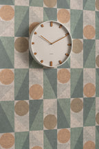 Karlsson wandklok Grace, wit, sfeerfoto: aan wand met geometrisch behang in groen, beige en terracotta