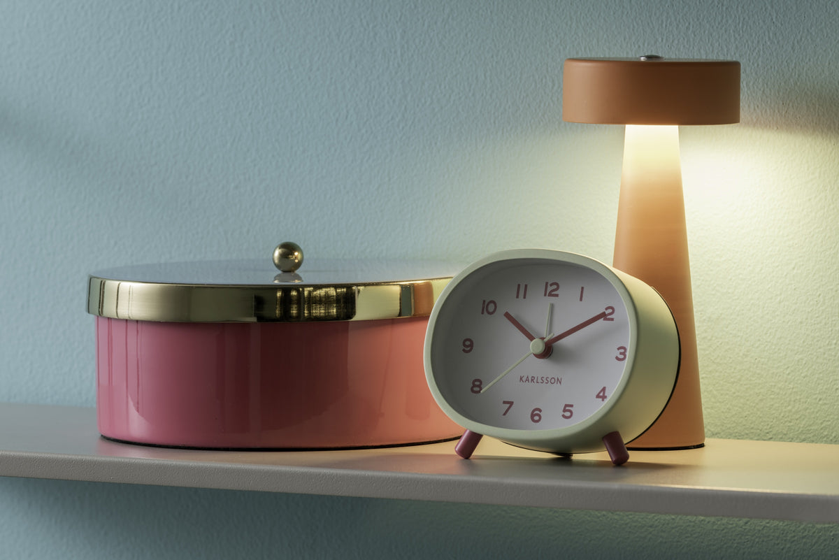 Karlsson wekker Cheeky Oval, zachtgroen, sfeerfoto: op plank naast roze trommel en oranje lamp