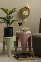Karlsson koekoeksklok Grato Cuckoo, okergeel en zachtgeel, sfeerfoto: boven krukjes met plant, wijnglas en fauteuil