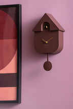 Karlsson koekoeksklok Modern Cuckoo Oro, bruin, sfeerfoto: aan lila muur naast ingelijste poster