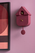 Karlsson koekoeksklok Modern Cuckoo Oro, paars, sfeerfoto: aan lila muur naast ingelijste poster