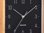 Karlsson wandklok Neat Cuadrado, zwart, detail: witte wijzers en cijfers, gouden middenpunt, Karlsson-logo
