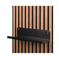 Zwarte metalen wandplank van Silentlines op een licht eiken wandpaneel