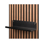 Zwarte metalen wandplank van Silentlines op een licht eiken wandpaneel