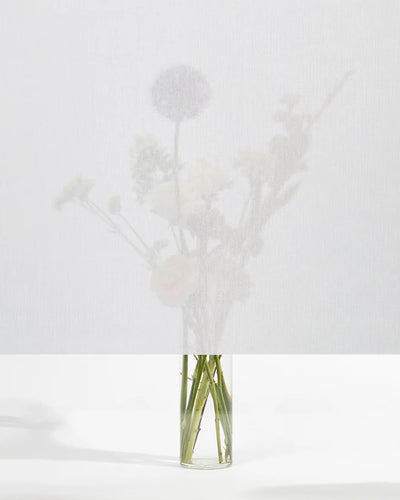 Squid raamtextiel Chalk (wit): transparant textiel voor het raam, met een boeket bloemen zichtbaar erachter