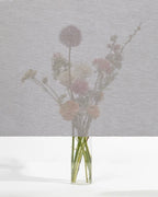 Squid raamtextiel Oak (beige): transparant textiel voor het raam, met een boeket bloemen zichtbaar erachter