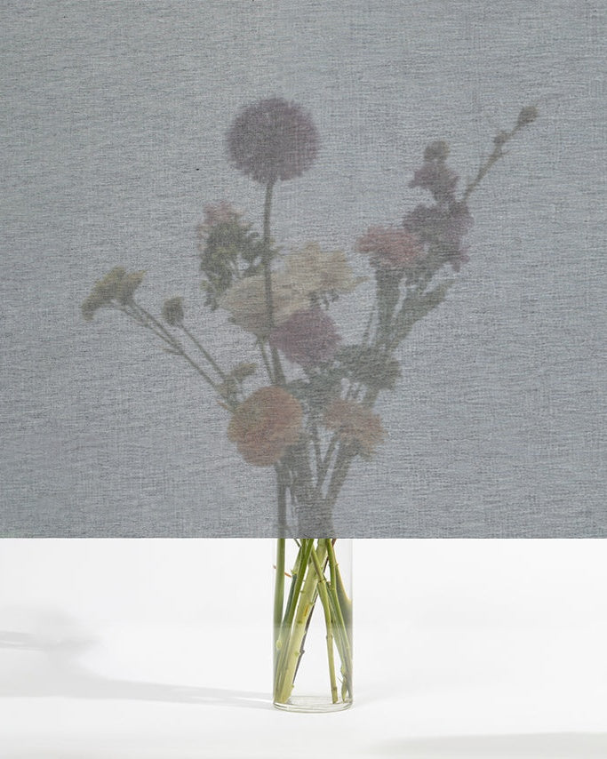 Squid raamtextiel Rock (grijs): transparant textiel voor het raam, met een boeket bloemen zichtbaar erachter