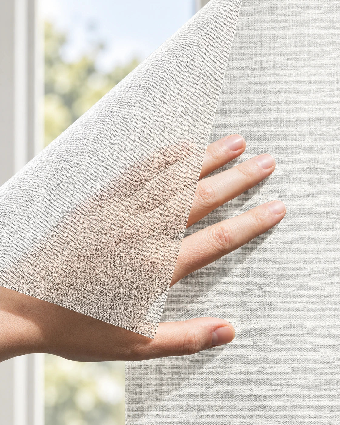 Squid raamtextiel op maat Chalk - Wit: hand tilt een hoek van het doorzichtige raamtextiel op voor een raam